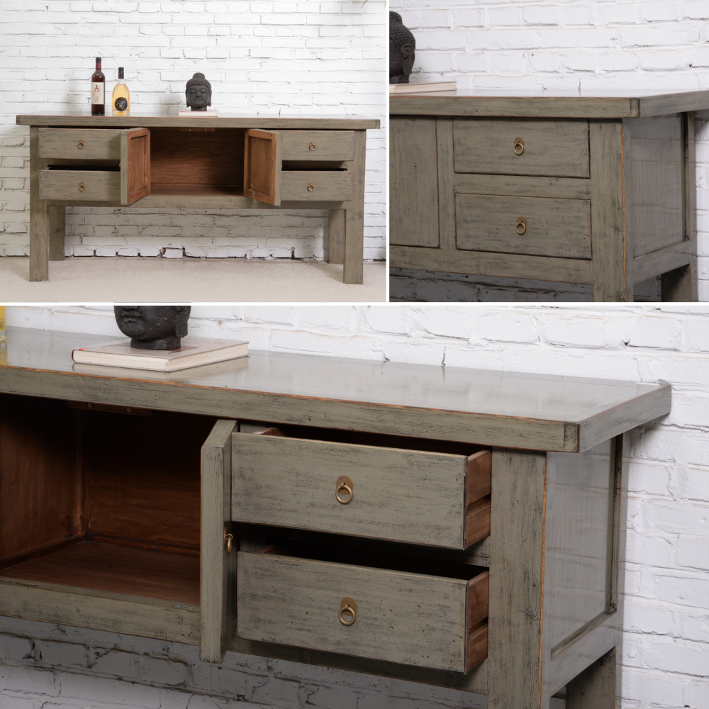 Wooden console with drawers against a white brick wall.