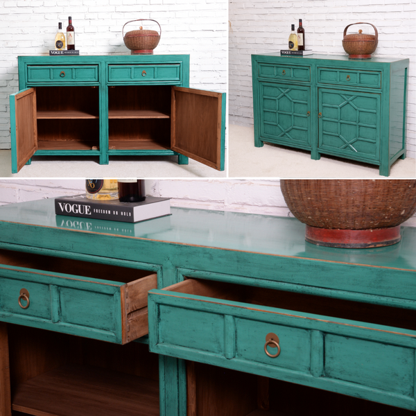 Teal wooden sideboard with open doors against a white brick wall.