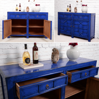 Blue sideboard with open doors and decorative items on a white brick wall background.