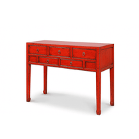 Red console table with multiple drawers on a white background